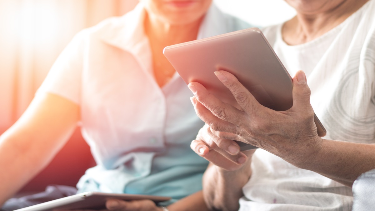 Zwei Frauen halten ein mobiles Gerät in der Hand