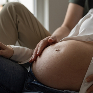 Mann reibt den Bauch seiner schwangeren Frau