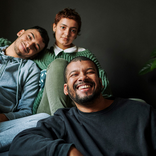Familie sitzt zuhause auf Sofa