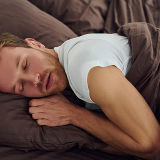 Mann, der im Bett schl&auml;ft