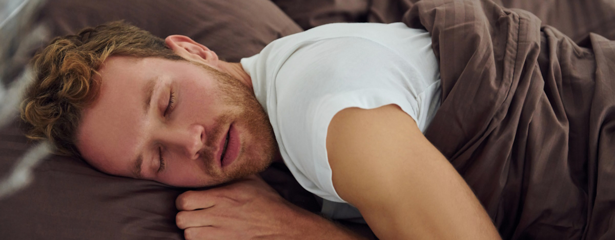 Mann, der im Bett schl&auml;ft