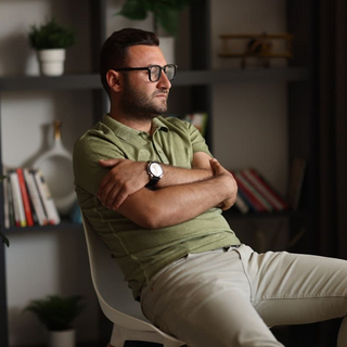 Overthinking: Ein Mann sitzt auf einem Stuhl und schaut nachdenklich aus dem Fenster.