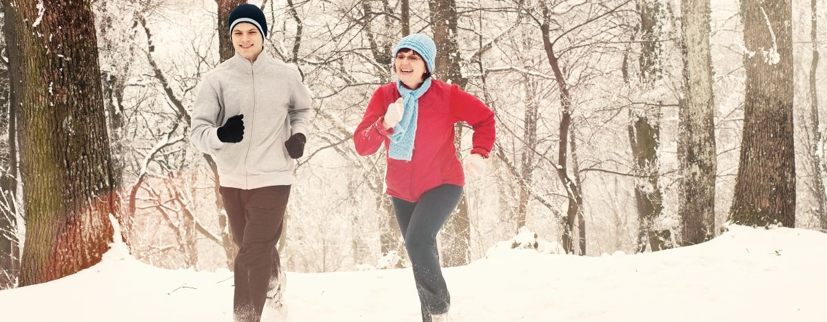 Junger Mann und &auml;ltere Frau joggen im Schnee