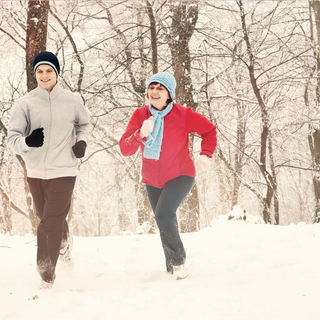 Junger Mann und &auml;ltere Frau joggen im Schnee