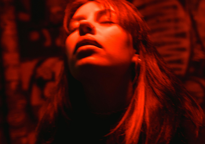 Eine junge Frau wirkt high auf Partydrogen.