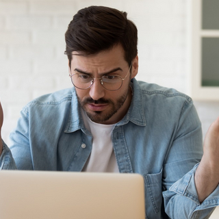 Frustrierter Mann vor einem Laptop