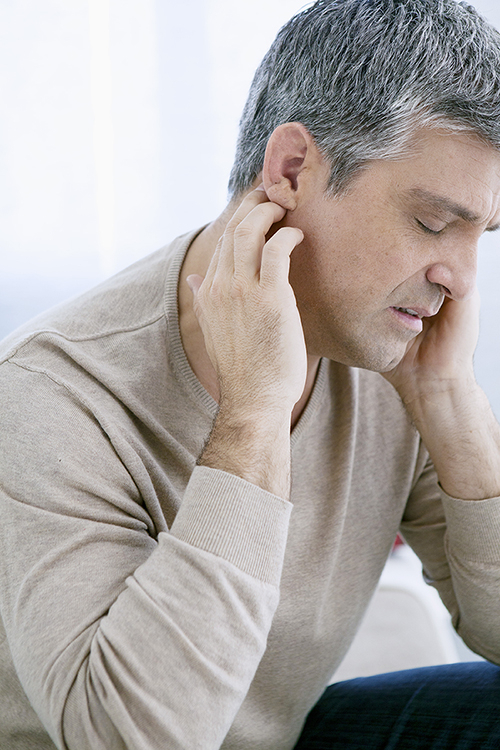 Mann fast sich gequ&auml;lt an die Ohren