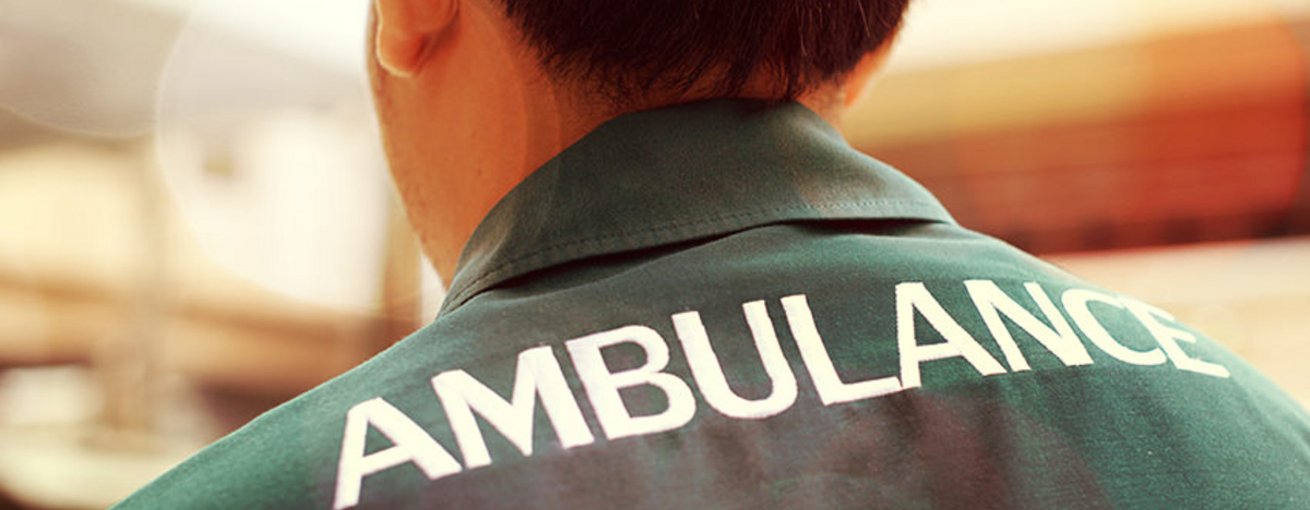 BKK VBU Krankenversicherung im Ausland: R&uuml;ckansicht eines Helfers mit &quot;Ambulance&quot;-Jacke