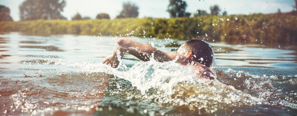 Mann schwimmt in einem See