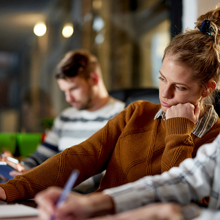 Gelangweilte Frau, die im B&uuml;ro am Laptop arbeitet.