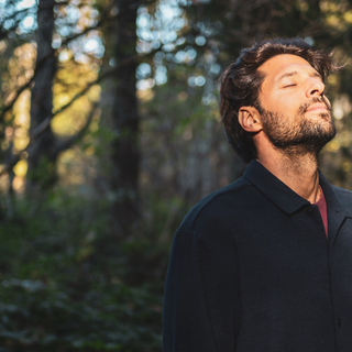 Mann im Wald, der tief durchatmet