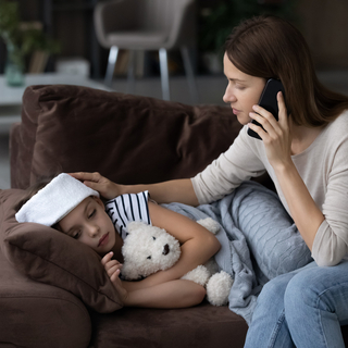 Frau ruft den Arzt f&uuml;r ihr krankes Kind