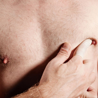 Mann dr&uuml;ckt Brust mit Finger.