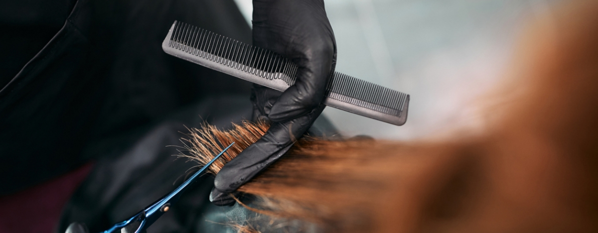 Friseur schneidet die Haarspitzen einer Frau