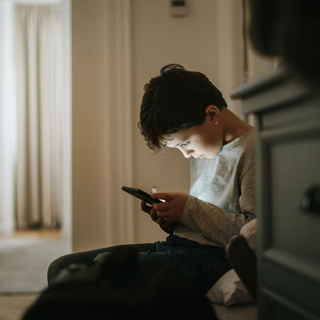 Junge spielt Videospiele zu Hause am Smartphone.