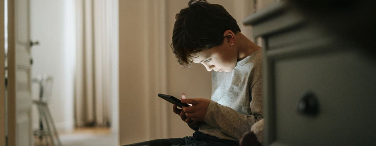 Junge spielt Videospiele zu Hause am Smartphone.