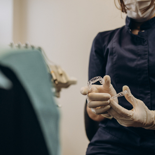 Eine Zahn&auml;rztin, die eine Zahnschiene in den H&auml;nden h&auml;lt.