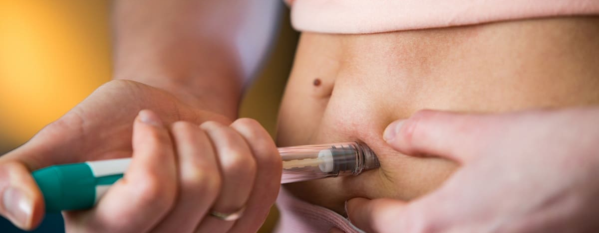 Frau macht Injektion mit Spritzenstift