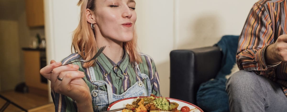 Eine junge Frau genie&szlig;t ihr zuckerfreies Essen.