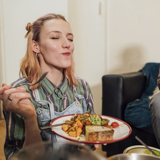 Eine junge Frau genie&szlig;t ihr zuckerfreies Essen.