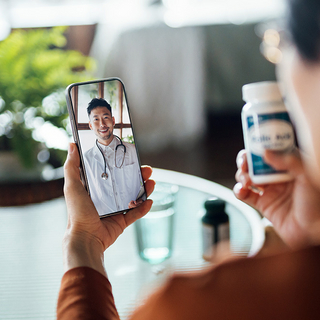 Frau, die einen virtuellen Termin mit dem Arzt online hat