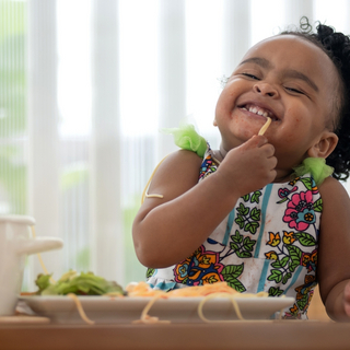 kleines M&auml;dchen lacht beim Nudel-Essen