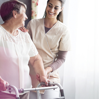 BKK VBU Pflegeportal ambulante Pflegeleistungen: Frau mit Gehilfe und Betrueuung durch Pflegerin