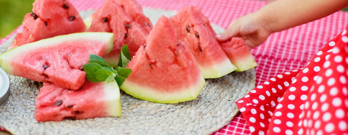 M&auml;dchen greift nach Wassermelone