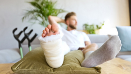 Junger Mann mit gebrochenem Fu&szlig;