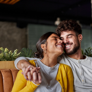 Ein verliebtes Paar h&auml;lt H&auml;ndchen und l&auml;chelt.