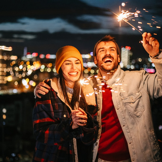 Ein paar mit Wunderkerzen feiert Silvester.