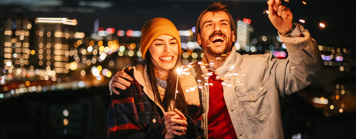 Ein paar mit Wunderkerzen feiert Silvester.