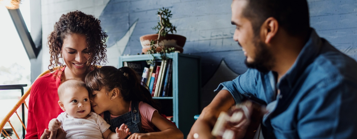 Vater spielt Gitarre, singt und hat Spa&szlig; mit seiner Familie