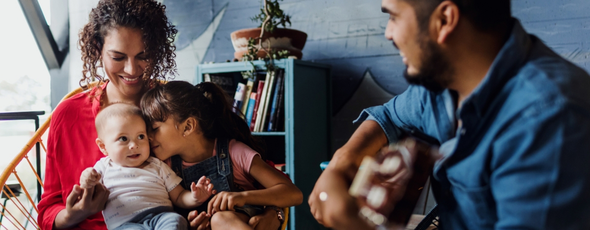 Vater spielt Gitarre, singt und hat Spa&szlig; mit seiner Familie