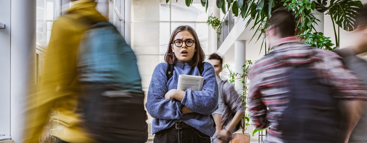 Eine Studentin mit Brille schaut &auml;ngstlich und schockiert.