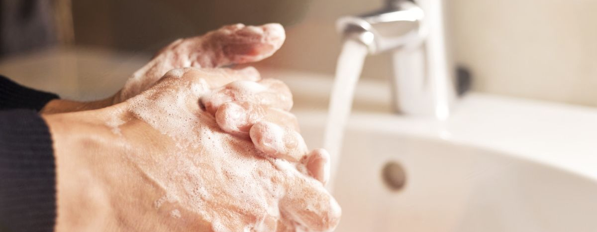 Jemand w&auml;scht sich mit viel Seife unter flie&szlig;endem Wasser die H&auml;nde