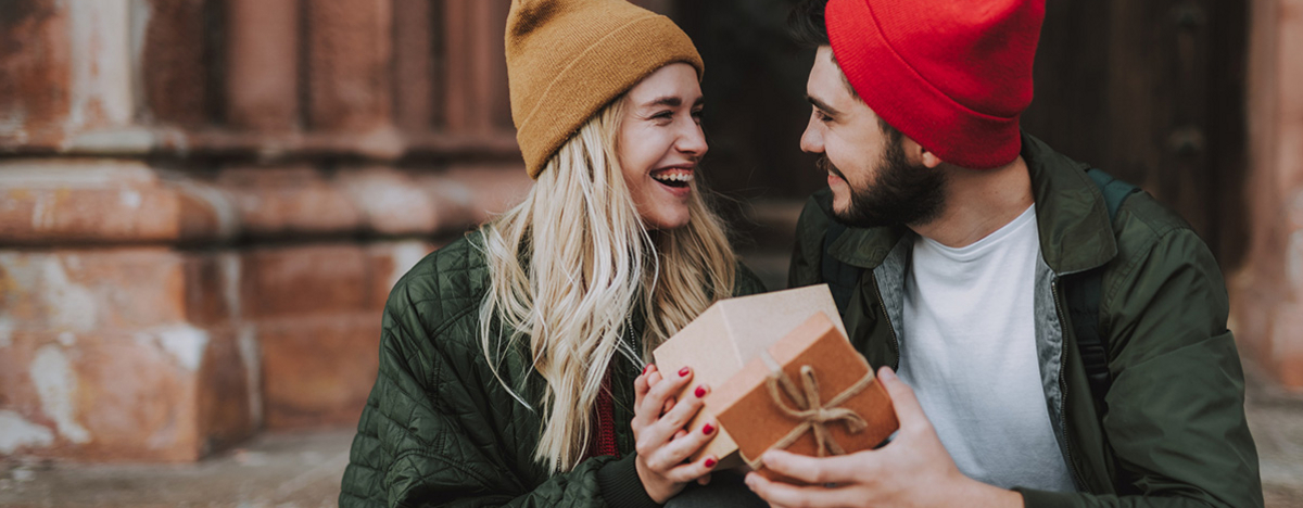 Junges Paar h&auml;lt ge&ouml;ffnete Geschenkbox
