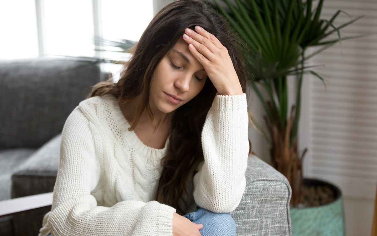 Frau h&auml;lt sich die Stirn und ist traurig