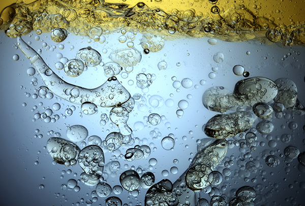 &Ouml;lblasen in blauem Wasser