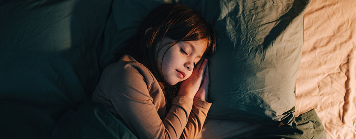 Kind schl&auml;ft im Bett