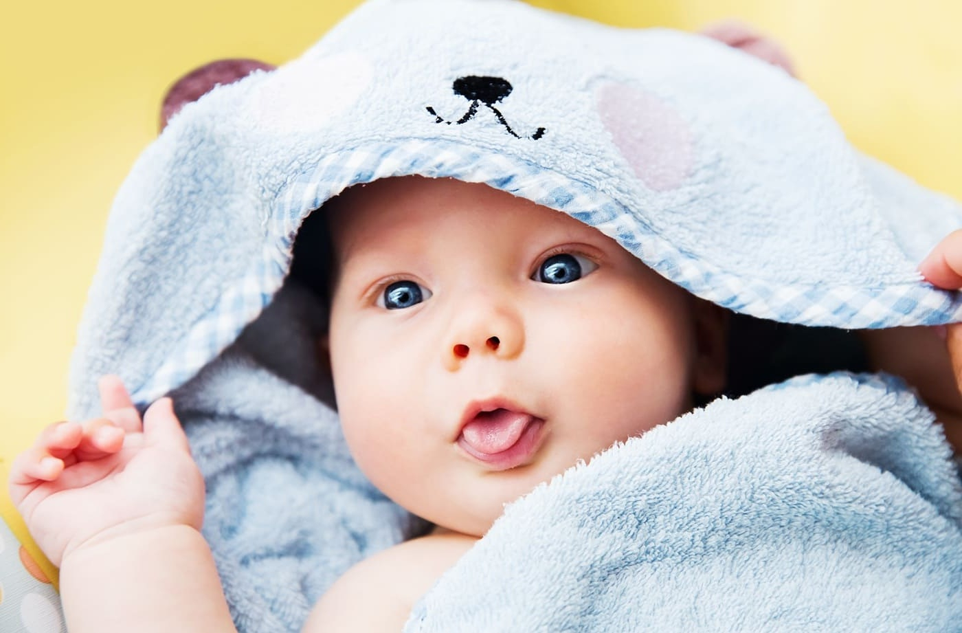 S&uuml;&szlig;es Baby Kind nach dem Bad mit Handtuch auf dem Kopf.