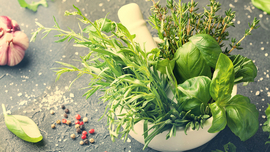 Ein M&ouml;rser gef&uuml;llt mit verschiedenen K&uuml;chenkr&auml;utern