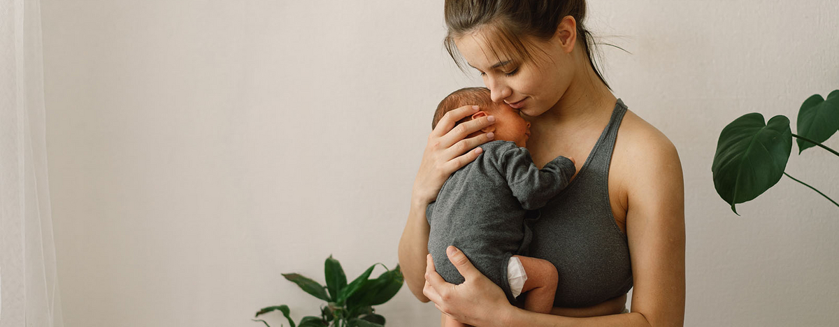 Junge Frau h&auml;lt Baby in ihrem Arm