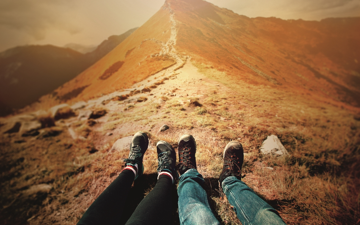 Paar liegt am Gipfel eines Berges und entspannt nach dem Wandern