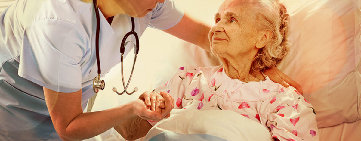 Krankenschwester hilft einer &auml;lteren Frau im Bett