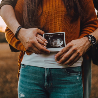 Babybauch einer Frau mit Ultraschallbild
