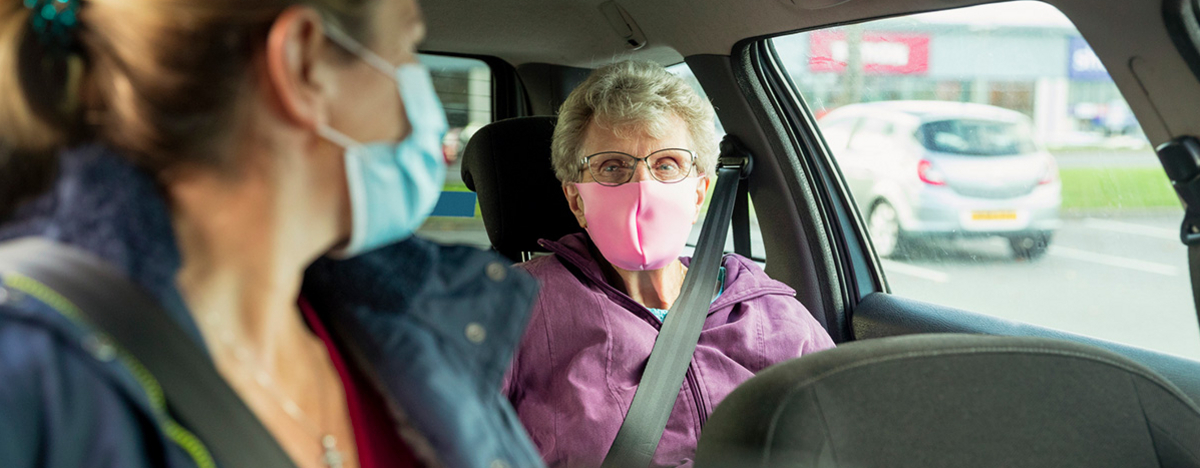Pflegerin mit &auml;lterer Patientin im Auto
