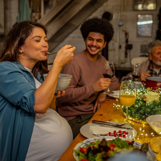 schwangere Frau ist auf einer Feier einen Salat