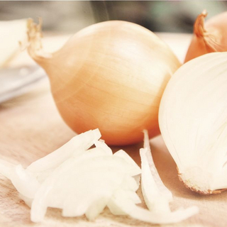 Aufgeschnittene Zwiebel liegt auf einem Schneidebrett