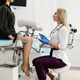 Eine junge Frau sitzt auf dem Behandlungsstuhl einer Frauen&auml;rztin.